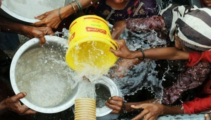 The representational image shows people getting water in their containers. — AFP/File