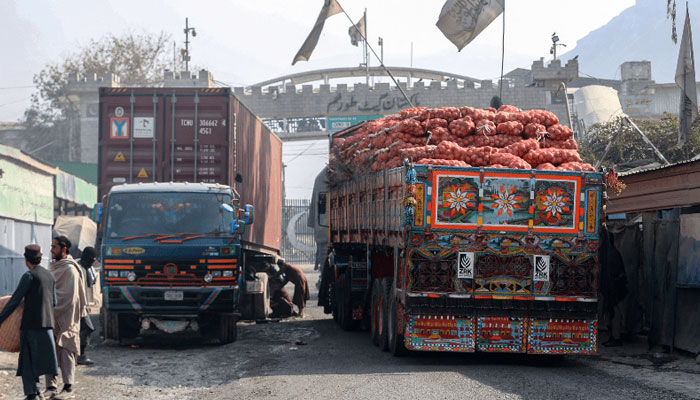 Trucks carrying goods pass through the zero point Torkham border crossing between Afghanistan and Pakistan, in Nangarhar province on January 23, 2024. — AFP