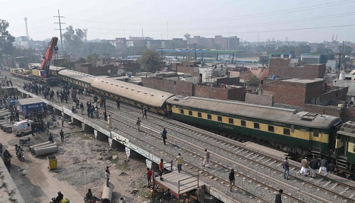 Rescue workers and railway personnel use a crane to clear the tracks after a train derailed near Lahore on January 31, 2025. — AFP