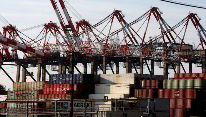 Containers are stacked beneath cranes at Port Newark Container Terminal as U.S. East Coast and Gulf ports resumed operations Friday after unionised dockworkers reached a tentative labour agreement with an employer group for a new contract, ending a three-day strike in Newark, New Jersey, US, October 4, 2024. — Reuters