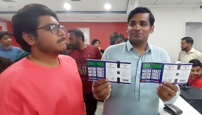 Cricket fan gestures after buying tickets for the inauguration match of the ICC Mens Champions Trophy 2025 at a designated centre in Karachi. — Reporter