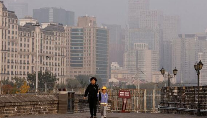 People walk at the Ming Dynasty City Wall Relics Park, as Beijing issues orange alert for heavy air pollution, in Beijing, China, on October 31, 2023. — Reuters