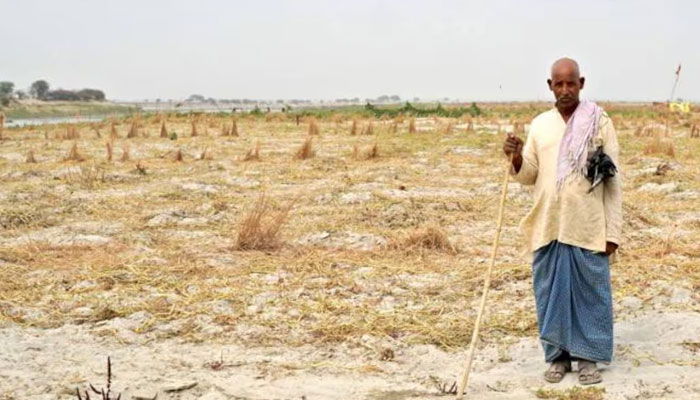Shiv Shankar, a 66-year-old Indian buffalo herder, stands in front of a dry pit intended for water storage for agriculture amid soaring temperatures in Prayagraj, India, on May 15, 2024. — AFP