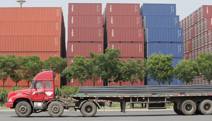 A truck carrying steel products drives past containers outside a logistics center near Tianjin Port, in northern China, May 16, 2019. — Reuters
