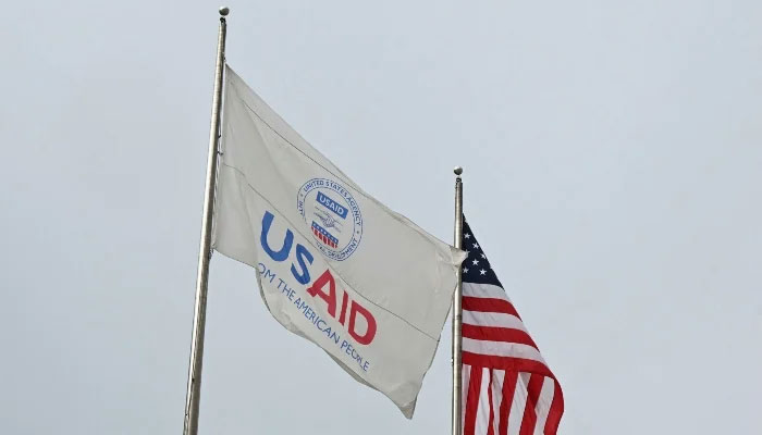 A USAID and American flag fly outside of USAID headquarters in Washington, DC, on February 3, 2025. — AFP