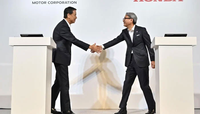 Nissan and Honda motors officials shaking hands. — AFP/File