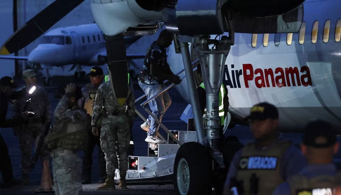 Members of the National Border Service (SENAFRONT) keep watch as a Colombian migrant, who was detained after crossing into Panama irregularly through the dangerous Darien Gap, boards the first US funded repatriation flight handcuffed and shackled, at Tocumen International Airport, in Panama City, Panama August 20, 2024. — Reuters