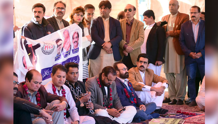 Journalists hold a banner during a hunger strike protest against PECA amendments, outside the press club, in Islamabad on 12, 2025. — Online