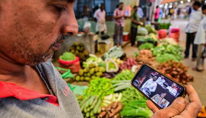 A man watches a live broadcast of Sri Lankas President Anura Kumara Dissanayake presenting the 2025 budget to parliament. —AFP/File