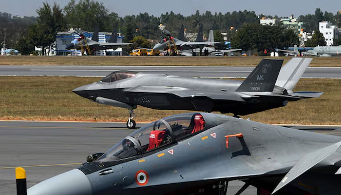 A F-35 fighter jet moves past Indian Air Forces Sukhoi Su-30MKI fighter jet parked on tarmac during the Aero India 2025 air show at Yelahanka air base in Bengaluru, India, February 11, 2025.— Reuters