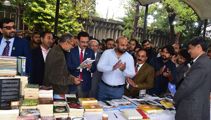 Punjab Education Minister Rana Sikandar Hayat Khan  (centre) visits a stall during a three-day book fair organised by Punjab University at the IER Corridor, New Campus on February 20, 2025. — Facebook@UniversityOfThePunjab.Official
