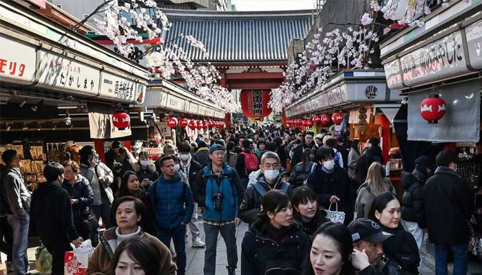 People walk along the main shopping street in the popular tourist destination of Asakusa in central Tokyo on February 21, 2025. — AFP