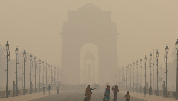Women walk on a road near India Gate as the sky is enveloped with smog after Delhis air quality worsened due to air pollution, in New Delhi, India, November 19, 2024. — Reuters