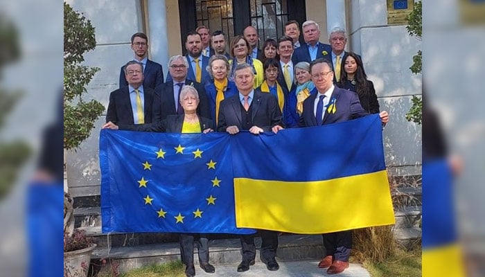 Ambassador of Ukraine to Pakistan Markian Chuchuk (centre) holding EU and Ukrainian flags with others on February 24, 2025. — Facebook@EUinPakistan