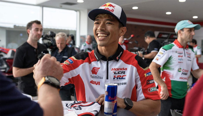 Thai rider Somkiat Chantra smiles as he signs autographs at a MotoGP launch event in Bangkok earlier this month. —AFP/File