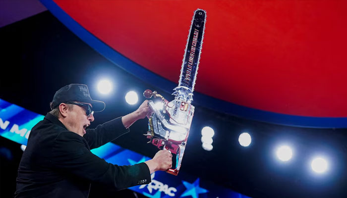 Elon Musk holds up a chainsaw onstage during the Conservative Political Action Conference (CPAC) in National Harbor, Maryland, US, February 20, 2025.—Reuters