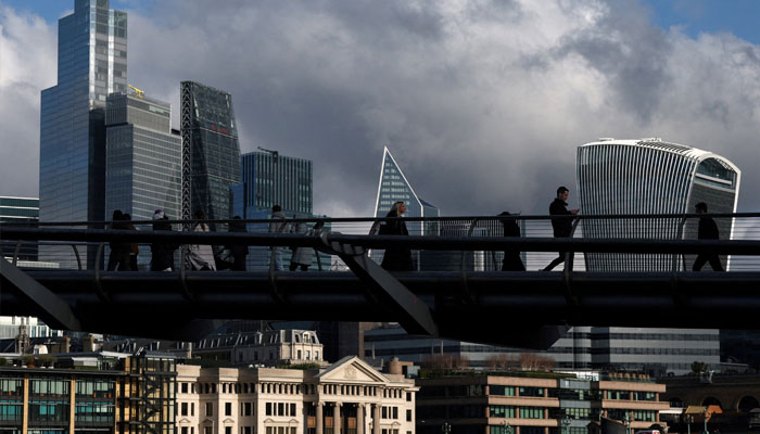 People cross the Millenium Bridge with skyscrapers of the City of London financial district seen behind, in London, Britain, February 6, 2025. —Reuters