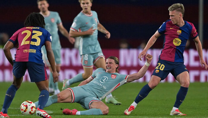 Atletico Madrids English midfielder Conor Gallagher (centre) vies for the ball with Barcelonas Spanish forward Daniel Olmo (right).— (AFP)
