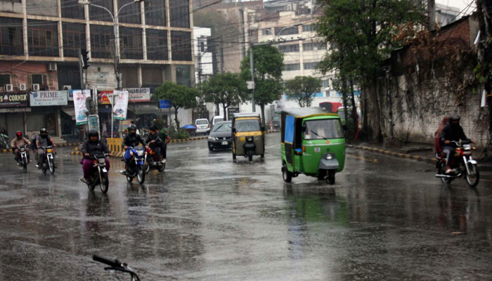 Commuters make their way amid rain showers at Shimla Hill in Lahore on February 27, 2025. — PPI