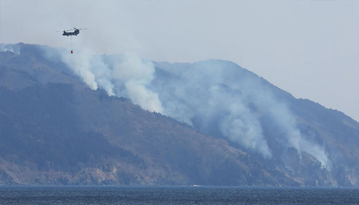A helicopter is pictured above the wildfire near Ofunato. —AFP/File