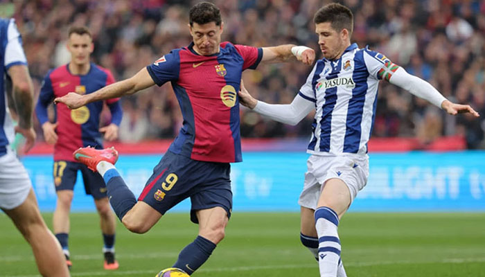 Barcelonas Polish forward  Robert Lewandowski (centre) and Real Sociedads Spanish midfielder Pablo Marin vie for the ball during the Spanish league football match between FC Barcelona and Real Sociedad at Estadi Olimpic Lluis Companys in Barcelona on Sunday, March 2, 2025.— AFP