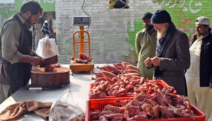 A butcher prepares chicken meat for customers at his shop on January 5, 2025. — Online