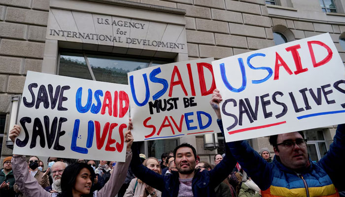 People hold placards, as the USAID building sits closed to employees after a memo was issued advising agency personnel to work remotely, in Washington, DC, US, February 3, 2025.— Reuters