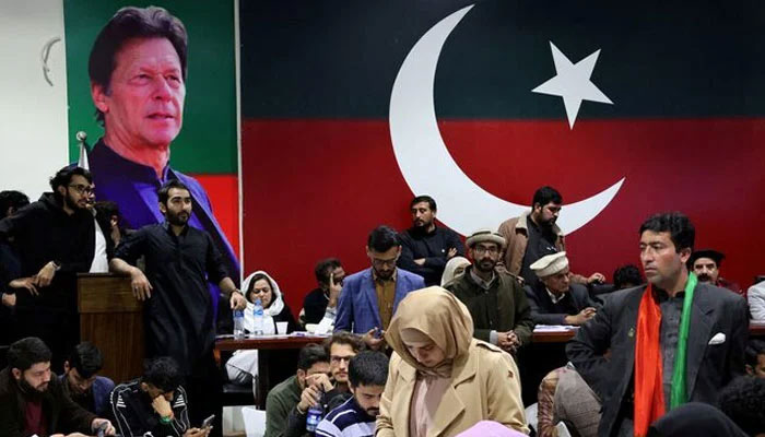 Representational image shows PTI volunteers looking on as they watch results on TV screens after the end of the polling during a general election at the partys main office in Islamabad, February 8, 2024. — Reuters