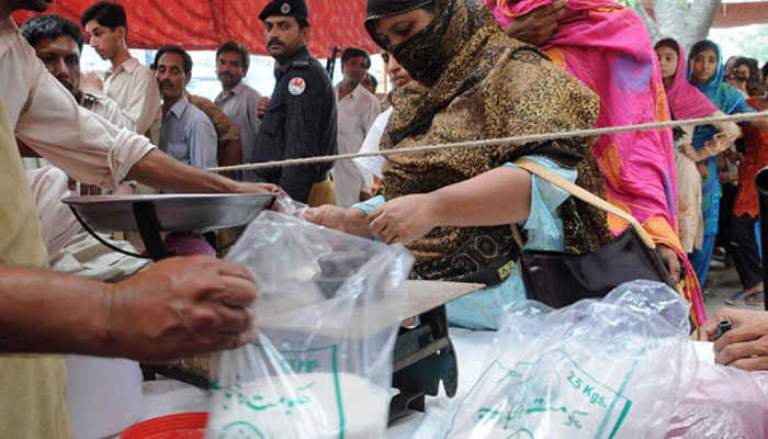A woman queues to buy sugar at a fixed rate in Lahore. — AFP/File