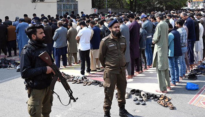 People offer prayers while security personnel stand alert at Shimla Pahari Chowk on March 7, 2025. — APP