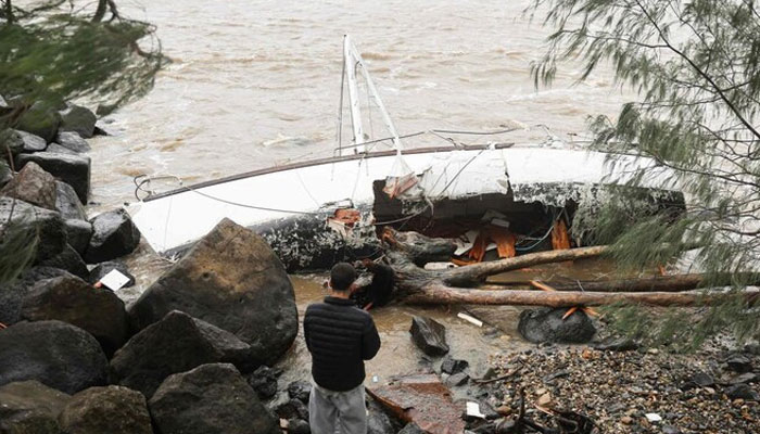 A yacht swept away by the waves rests at Point Danger on the southern end of the Gold Coast. — AFP/File