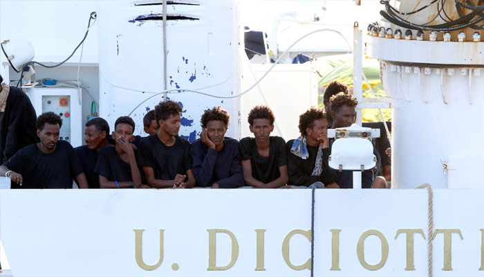 Migrants wait to disembark from the Italian coast guard vessel Diciotti at the port of Catania, Italy, August 22, 2018. — Reuters
