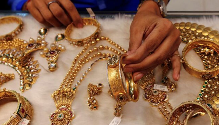 A woman looks at a gold bangle inside a jewellery showroom at a market in Mumbai January 15, 2015. — Reuters