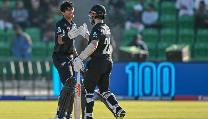 New Zealands Rachin Ravindra (left) celebrates with teammate Kane Williamson after scoring a century (100 runs) during the ICC Champions Trophy one-day international (ODI) semi-final cricket match between New Zealand and South Africa at the Gaddafi Stadium in Lahore on March 5, 2025. — AFP