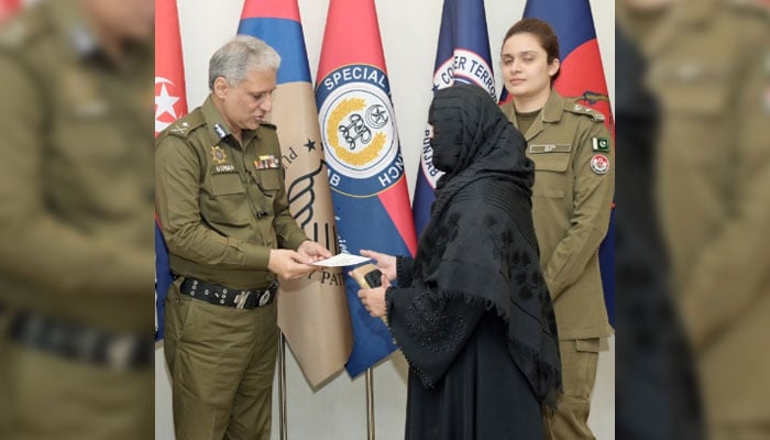 Inspector General of Police (IGP) Punjab Dr Usman Anwar distributes cheque to a family of martyr on November 15, 2024. — Facebook@PunjabPolicePakistanOfficial