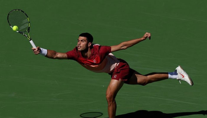 Carlos Alcaraz of Spain stretches to play a forehand against Quentin Halys of France in their second round match during the BNP Paribas Open at Indian Wells Tennis Garden on March 08, 2025 in Indian Wells, California. — AFP