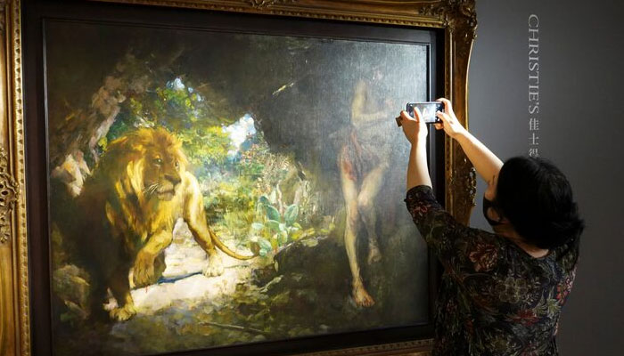 A journalist takes pictures of the 1924 painting by Xu Beihong titled Slave and Lion during a media event before the item goes on an auction at Christies, in Hong Kong, China April 19, 2021. — Reuters