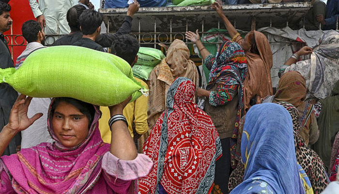 A representational image shows women collecting free bags of flour from a government distribution point. — AFP/File