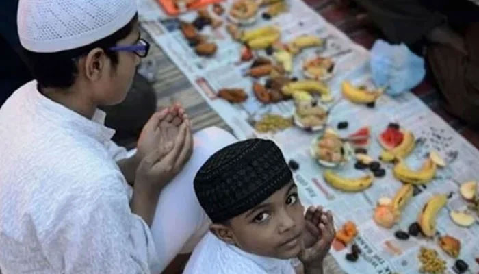 This image shows two children praying at the time of breaking the fast. — AFP/File