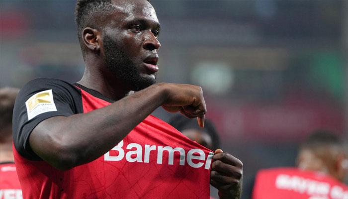 Bayer Leverkusen striker Victor Boniface points to the clubs badge after scoring in Fridays 3-1 win over Bochum, March 28, 2025. —AFP