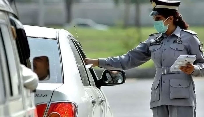 A representational image showing a traffic police official interacting with a commuter. — APP/File