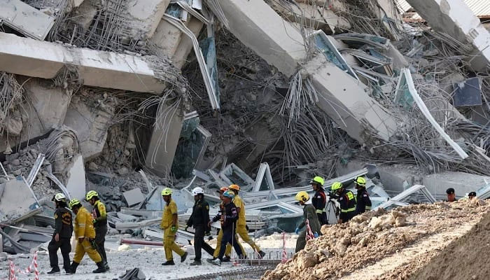Rescue personnel walk near a building that collapsed in Bangkok. — AFP/File