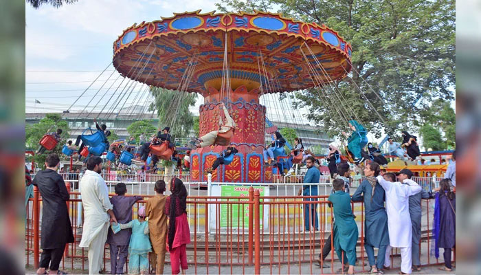 Youngsters enjoys swing in evening hours at a park on the 2nd day of Eid ul Azha on June 19, 2024. — Online