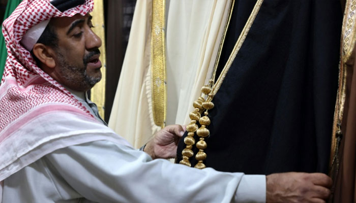 A Saudi tailor showing an Arabian robe made by him. — AFP/File