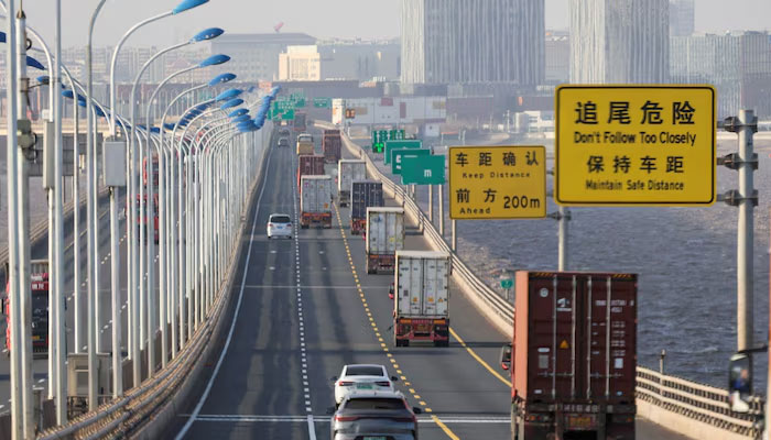 Trucks loaded with shipping containers pass over Donghai Bridge to exit Yangshan Port outside of Shanghai, China, February 7, 2025. — Reuters