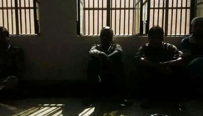 Representational image shows prisoners sitting inside a dark lockup. — AFP/File