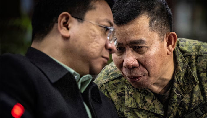 Colonel Medel Aguilar (right), spokesperson for the Armed Forces of the Philippines, whispers to Jonathan Malaya, spokesperson for the National Security Council. —Reuters/File