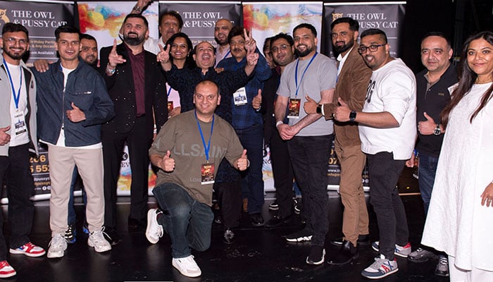 Ustad Rahat Fateh Ali Khan gestures during a group photo with officials. — Reuters