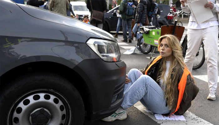 Climate activist Anja Windl sitting infront of car. —AFP/File