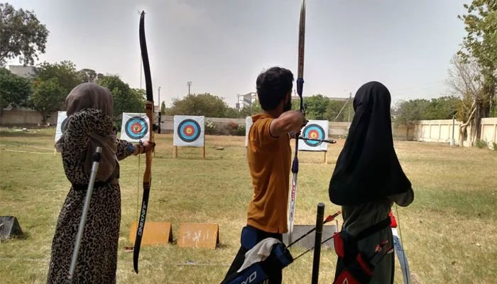 An undated image shows three archers taking aim at their targets during an archery camp at Karachi University, Karachi. — Facebook@QAA Archery
